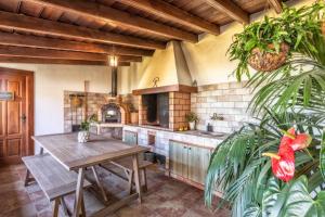 eine große Küche mit einem Holztisch und einer Theke in der Unterkunft El Bebedero by Huskalia - private pool in Los Sauces