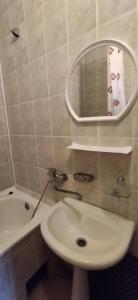 een badkamer met een wastafel, een spiegel en een bad bij Санаторій Збруч in Sataniv