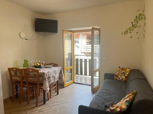 a living room with a table and a couch at Borgo Bliss Apartment in Tenno