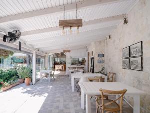 a patio with tables and chairs and a ceiling at Georgia's Garden by Omilos Hotels in Amoudara Herakliou
