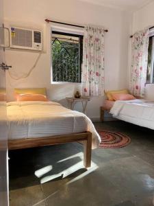 a bedroom with two beds and a window at Home Stay in Mumbai