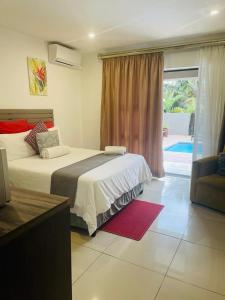 a bedroom with two beds and a window with a patio at M-crystals in Richards Bay