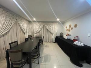 a dining room with a black table and chairs at M-crystals in Richards Bay