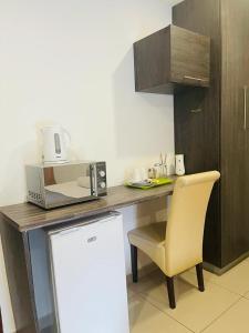 a kitchen with a desk with a microwave and a chair at M-crystals in Richards Bay