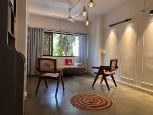 a living room with a table and chairs and a window at Home Stay in Mumbai