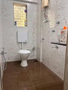 a bathroom with a white toilet and a shower at Home Stay in Mumbai