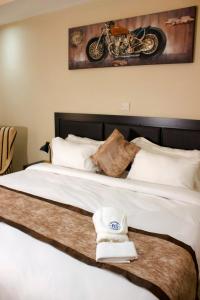 Un dormitorio con una cama con una motocicleta. en Milestone Hotels en Lusaka
