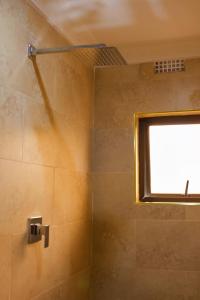 ein Bad mit einer Dusche und einem Fenster in der Unterkunft Milestone Hotels in Lusaka