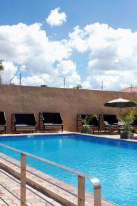 una piscina con sillas y sombrilla en Milestone Hotels en Lusaka