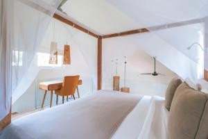 a bedroom with a white bed and a desk at Sun & Moon Villa in Canggu