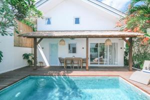 a villa with a swimming pool and a house at Sun & Moon Villa in Canggu