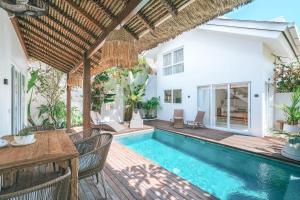 a villa with a swimming pool and a house at Sun & Moon Villa in Canggu