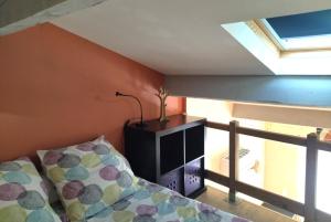 1 dormitorio con 1 cama con lámpara y ventana en Chambre d'hôtes Le Cocon, en Saint-Géniès-de-Malgoirès