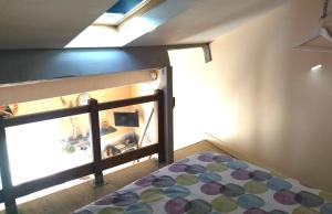 1 dormitorio con cama y ventana con colcha en Chambre d'hôtes Le Cocon, en Saint-Géniès-de-Malgoirès