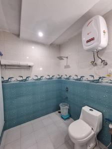 uma casa de banho com um WC branco e uma parede azul em Hotel Stay Well em Banikhet