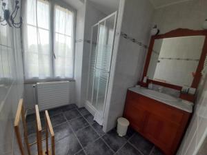 ein Bad mit einem Waschbecken und einem Spiegel in der Unterkunft La maison de Maria in Saint-Beauzire