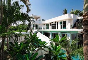 una vista exterior de una casa blanca con palmeras en Villas In Pattaya, en Jomtien Beach