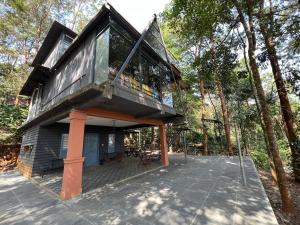 a tree house with a balcony on a deck at Wildrootstay 3 bed cottage in Pinangode