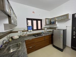 cocina con fregadero y nevera en Happy Villa Homestay - 2, en Chelakara