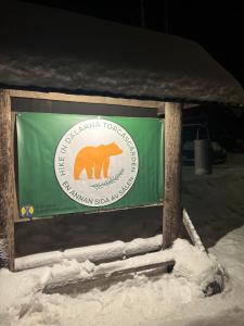a green sign with a bear on it in the snow at STF Sälen Torgåsgården in Lima
