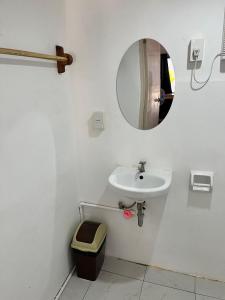 bagno bianco con lavandino e specchio di Ô Calme Guesthouse a San Vicente