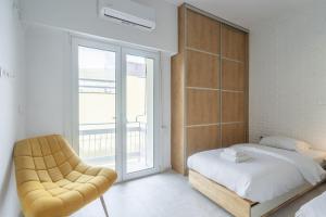 una camera con un letto e una sedia e una finestra di Artsy Kolonaki C - Greecing ad Atene