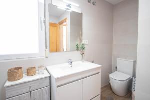 a bathroom with a sink and a toilet and a mirror at Luna Apartment by A3Rentals in Armilla