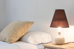 a lamp on a table next to a bed with a pillow at Luna Apartment by A3Rentals in Armilla