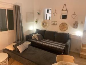 a living room with a black couch in a room at Maisonnette La petite Jeanne in Boves
