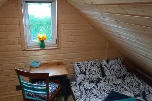 a room with a couch and a table and a window at Uroczy domek na Mazurach in Nowe Kiejkuty