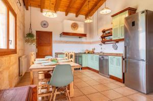 a kitchen with a table and a refrigerator at Maravillosa finca con piscina in Marratxi