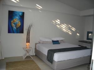 Aquaria Eco Resort في كانديداسا: غرفة نوم بسرير ودهان على الحائط