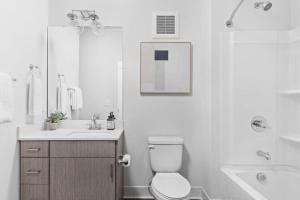 uma casa de banho branca com um WC e um lavatório em CozySuites Studio Apt in the Heart of Downtown em Indianápolis