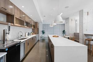 a large white kitchen with a large white counter top at Mid-Century Modern Studio CozySuites Downtown in Indianapolis