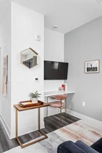 a living room with a desk and a table at Dream Apartment near Whole Foods CozySuites in Indianapolis