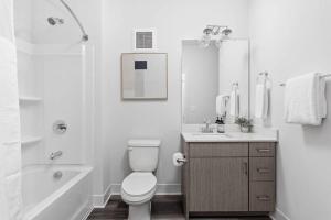 a white bathroom with a toilet and a sink at Dream Apartment near Whole Foods CozySuites in Indianapolis +13 photos