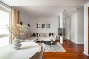 a living room with a couch and a table at Arena Ursynów Luxury Apartment in Warsaw