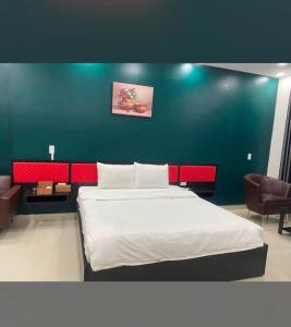 - une chambre avec un lit et un mur bleu dans l'établissement Hưng Phú Hotel HCM, à Hô-Chi-Minh-Ville