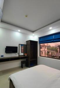 - une chambre avec un lit, une télévision et une fenêtre dans l'établissement Hưng Phú Hotel HCM, à Hô-Chi-Minh-Ville