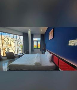une chambre avec un lit et un mur bleu dans l'établissement Hưng Phú Hotel HCM, à Hô-Chi-Minh-Ville