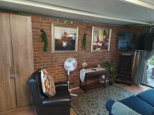 a living room with a brick wall at Urban Oasis Cape Town in Cape Town