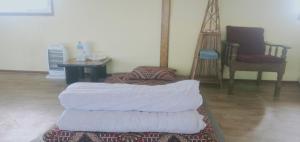 a room with a pile of blankets on a rug at Dadaghare Homestay & View Point Restaurant in Panauti