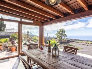 un tavolo in legno con un bicchiere di vino sul patio di Casa Pedrito - Cozy House, dreamy Terrace & Sea views a Los Llanos de Aridane