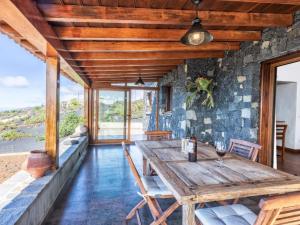 una sala da pranzo con tavolo e sedie in legno di Casa Pedrito - Cozy House, dreamy Terrace & Sea views a Los Llanos de Aridane