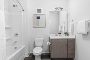 印第安納波利斯的住宿－Modern CozySuites Studio Apartment，白色的浴室设有卫生间、浴缸和水槽。