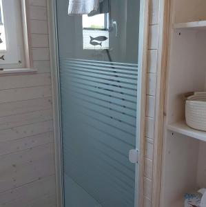 a glass shower door in a bathroom at Knobis-DREAM-PLACE in Fehmarnsund