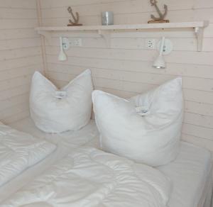 two white pillows sitting on top of a bed at Knobis-DREAM-PLACE in Fehmarnsund