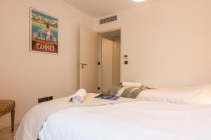 - deux lits assis l'un à côté de l'autre dans une pièce dans l'établissement Palm Beach - swimming pool - beach at few steps, à Cannes