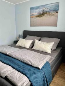 格拉爾－米里茨的住宿－discovAIR Graal Müritz -Haus Quisisana- Strandnah mit Netflix，卧室内的一张带两个枕头的床