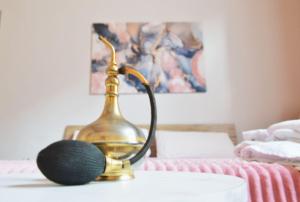 a brass lamp sitting on a table next to a bed at Casa Del Teatro in Pavia